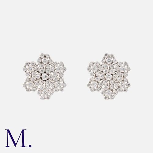 217 - A Pair Of Diamond Earrings in 18k white gold, designed as a pair of snowflakes, each set with round ... 