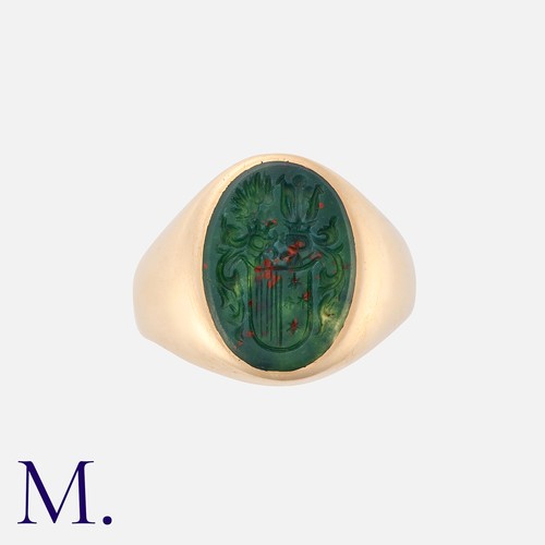 182 - An Intaglio Signet Ring in yellow gold set with an oval bloodstone with carved armorial intaglio.  M... 