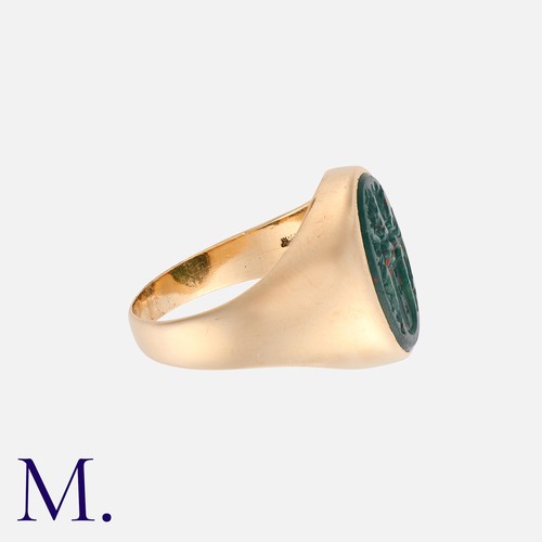 182 - An Intaglio Signet Ring in yellow gold set with an oval bloodstone with carved armorial intaglio.  M... 