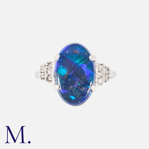 106 - A Black Opal And Diamond Ring in white gold, Set with a principal cabochon black opal of approximate... 