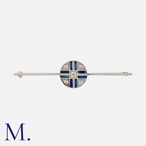 103 - An Art Deco Bar Brooch in white gold, comprising a platinum bar with a central circular motif set wi... 