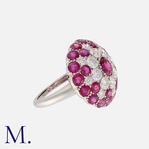 58 - A Ruby and Diamond Retro Cluster Ring in platinum in a bombé cluster arrangement.  Set with round cu... 