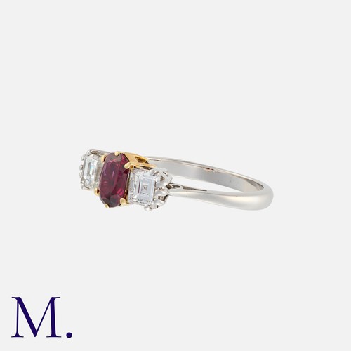 214 - A Ruby And Diamond Three Stone Ring in 18k yellow and white gold, set with a principal oval cut ruby... 