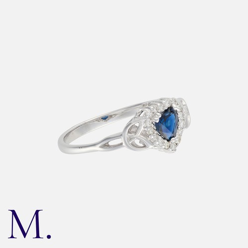 129 - A Sapphire And Diamond Heart Ring in white gold, set centrally with a heart shaped sapphire of appro... 