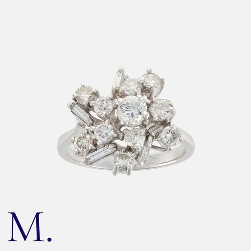 217 - A Diamond Cluster Ring in platinum, set with an array of round brilliant and baguette cut diamonds t... 