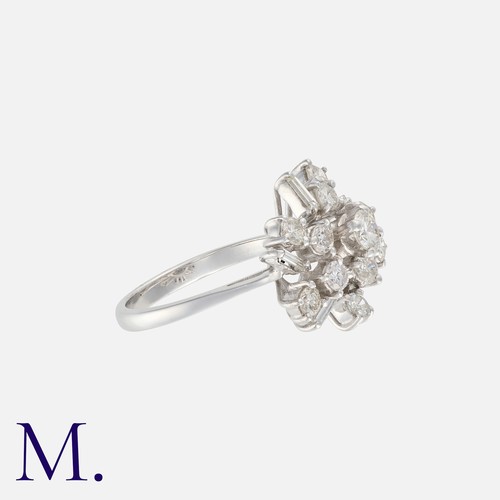 217 - A Diamond Cluster Ring in platinum, set with an array of round brilliant and baguette cut diamonds t... 