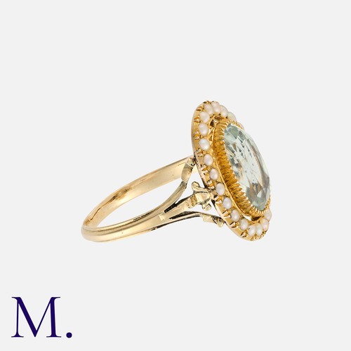 61 - An Aquamarine And Pearl Ring in yellow gold, comprising a principal oval cut aquamarine within a bor... 