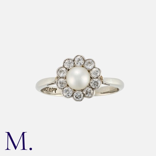 110 - A Pearl And Diamond Cluster Ring in 18k white gold and platinum, set with a central pearl of approxi... 