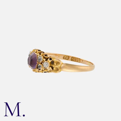 180 - An Antique Amethyst And Paste Ring in 15k yellow gold, set with a cushion cut amethyst, flanked eith... 