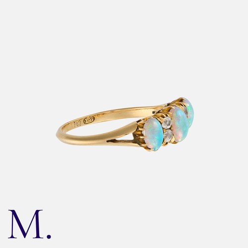 194 - An Opal And Diamond Ring in 18k yellow gold, set with three cabochon opal, punctuated by pairs of ol... 