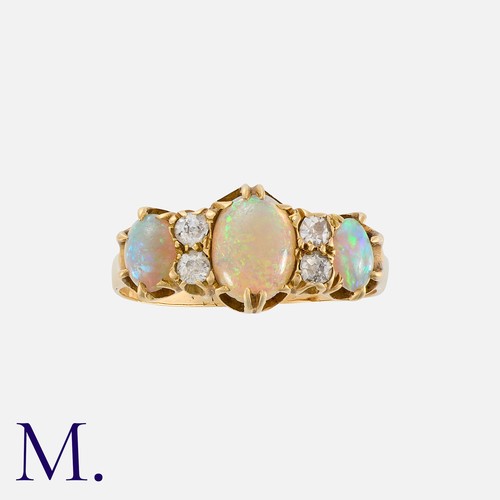 155 - An Opal And Diamond Ring in yellow gold, set with three cabochon opal, punctuated by pairs of old cu... 