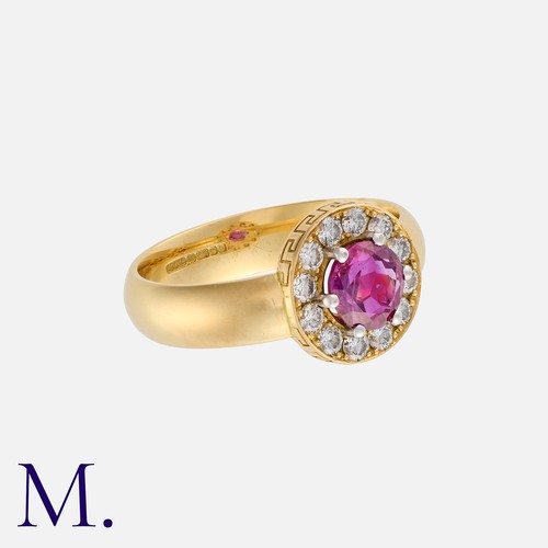 177 - A Ruby And Diamond Cluster Ring in 18k yellow gold, set with a central round cut ruby of approximate... 