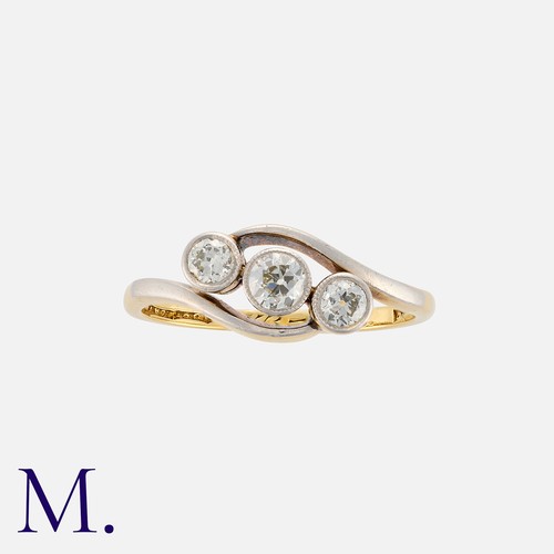 29 - A Diamond Three Stone Ring in 18k yellow gold and platinum, of crossover design, set with three old ... 