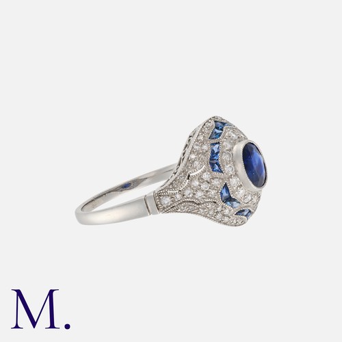 162 - An Art Deco Style Sapphire And Diamond Ring in Platinum, Set principally with an oval cut blue sapph... 