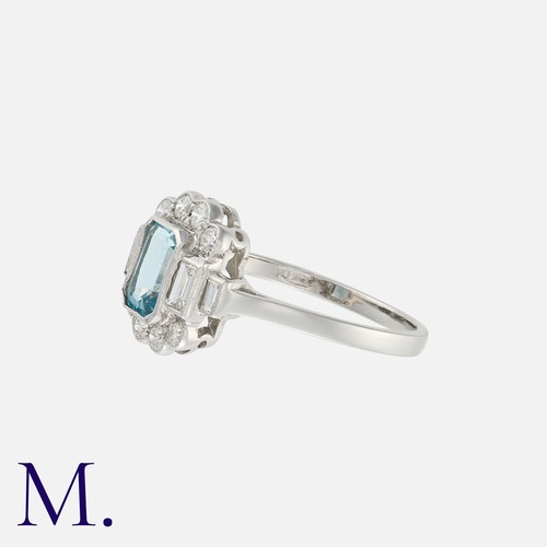 188 - An Aquamarine and Diamond Ring in platinum set with an emerald cut aquamarine with round and baguett... 