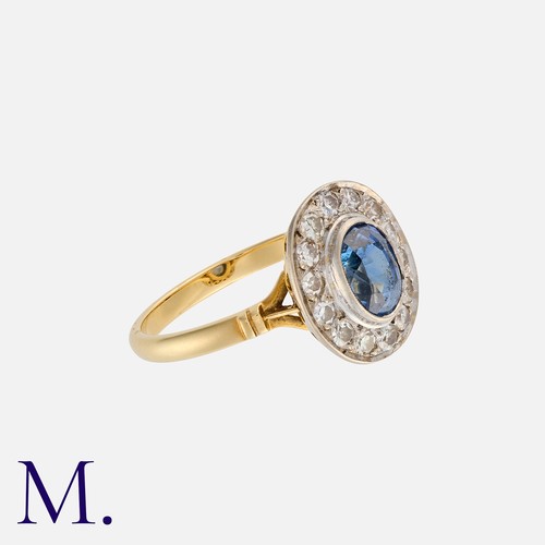 141 - A Sapphire and Diamond Cluster Ring yellow gold, set with an oval cut sapphire with round cut diamon... 