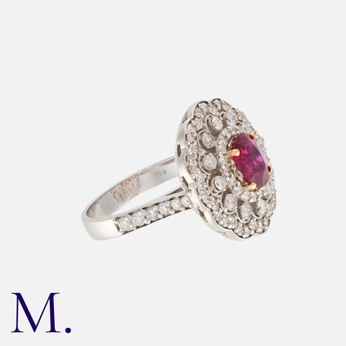 52 - A Ruby and Diamond Cluster Ring in 18K white gold, set to the centre with an oval cut ruby weighing ... 