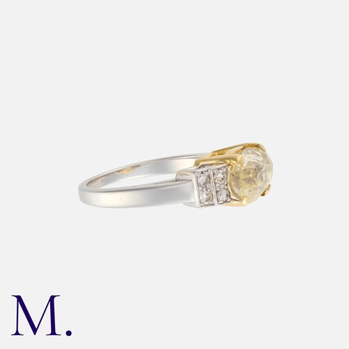 204 - A Yellow Sapphire and Diamond Ring in white and yellow gold, set with an oval-cut sapphire weighing ... 