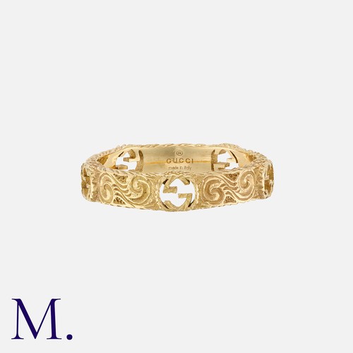 181 - GUCCI. An Engraved Gold Band in 18K yellow gold, with cut-out logos around the band.  Signed Gucci a... 