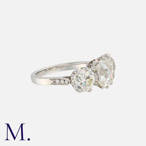 100 - An Old Cut Diamond Three Stone Ring in platinum, set with a principal old cut diamond of 3.14cts, fl... 