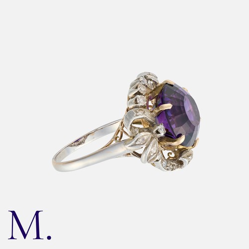 17 - An Amethyst And Diamond Ring in white gold, set with a central round cut amethyst of approximately 8... 