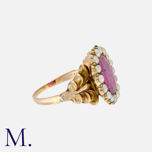 104 - A Ruby And Pearl Cluster Ring in 18k yellow gold, set with a principal oval cut ruby within a border... 