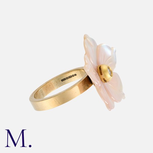 179 - A Mother Of Pearl And Diamond Ring in 9k yellow gold, the carved mother of pearl flower motif set ce... 