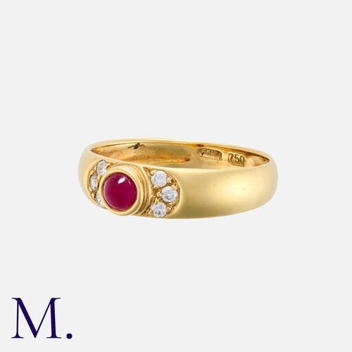 130 - A Ruby And Diamond Band Ring in 18k yellow gold, set with a cabochon ruby, flanked either side by a ... 