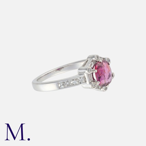 19 - A Ruby And Diamond Cluster Ring in white gold Set with a principal ruby of approximately 0.60ct, wit... 