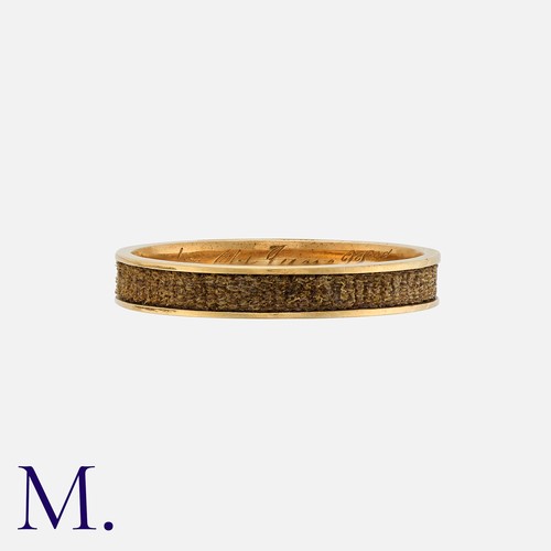 167 - An Antique Hairwork Mourning Ring in yellow gold, the gold band with a channel featuring woven hairw... 