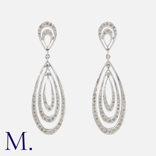 120 - A Pair Of Diamond Earrings in 18k white gold, comprising a pear shaped top suspending a trio of conc... 