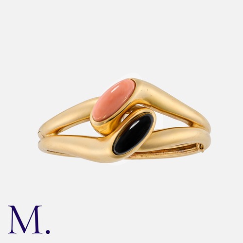 170 - BOUCHERON. A Vintage Coral and Onyx Bangle in 18K yellow gold, set with coral and onyx cabochons.  S... 