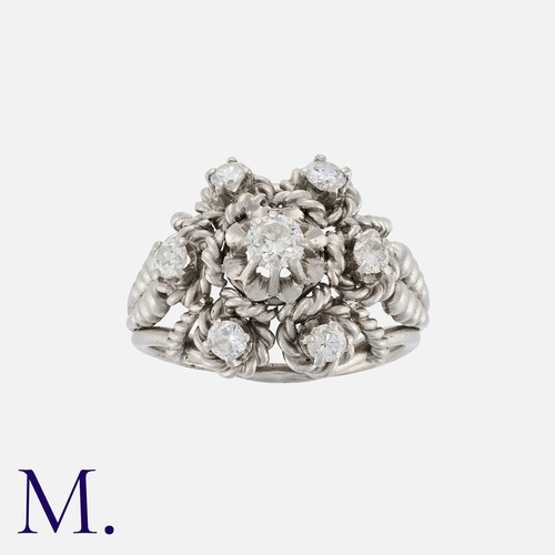 136 - A Retro Diamond Cluster Ring in platinum set with a centre diamond of approximately 0.25ct and six f... 