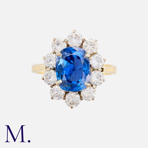 61 - A Burma Sapphire & Diamond Cluster Ring in 18K gold.  Oval cut sapphire weighing 3.84ct accompanied ... 