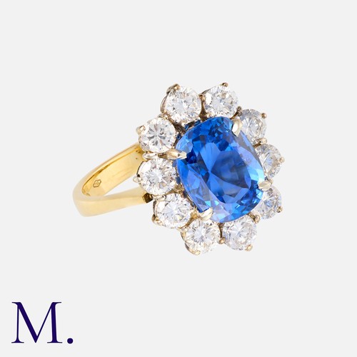 61 - A Burma Sapphire & Diamond Cluster Ring in 18K gold.  Oval cut sapphire weighing 3.84ct accompanied ... 