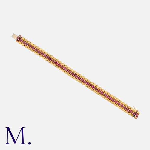 182 - MAUBOUSSIN. A Ruby Bracelet in 18K yellow gold set with round cut rubies along the length of the wov... 