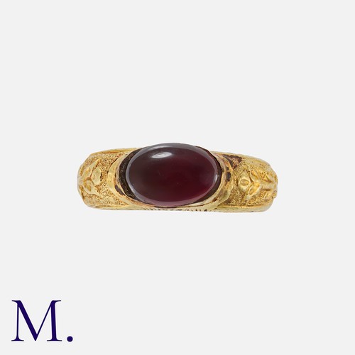 63 - An Antique Garnet Signet Ring in yellow gold with engravings around the hollow band.  The ring is se... 