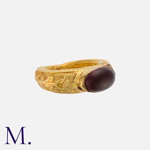 63 - An Antique Garnet Signet Ring in yellow gold with engravings around the hollow band.  The ring is se... 