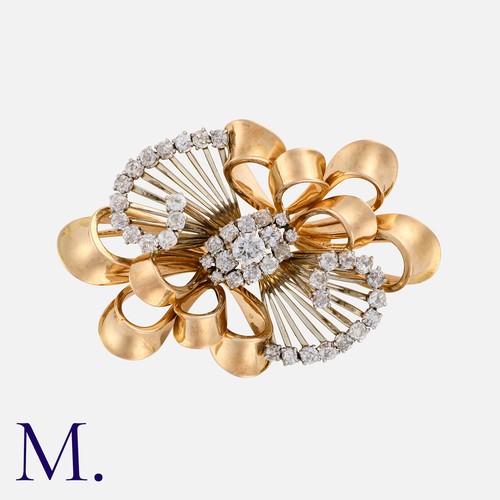 150 - A Retro Diamond Brooch in yellow and white gold, in a swirling design set with round cut diamonds we... 