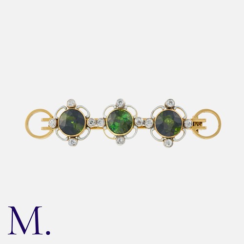 162 - A Tourmaline And Diamond Brooch in 18k yellow gold, comprising three round cut tourmalines, accented... 