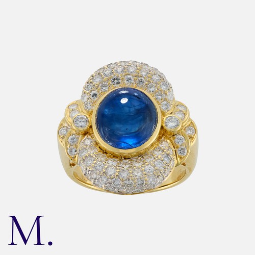 151 - A Sapphire And Diamond Cluster Ring in 18k yellow gold, set with a principal oval cabochon sapphire ... 