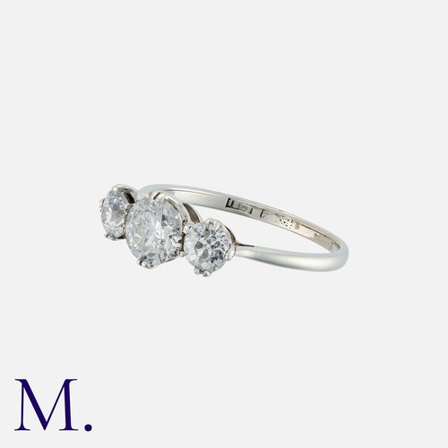 201 - A Diamond Three Stone Ring in 18k white gold, set a central round cut diamond of approximately 0.70c... 