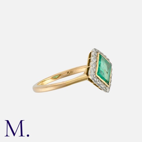 15 - An Emerald And Diamond Ring in 18k yellow gold and platinum, comprising a square emerald within a cl... 