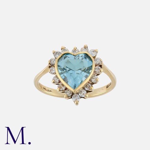 144 - An Aquamarine And Diamond Ring in 9k yellow gold, set with a heart shaped aquamarine within a cluste... 