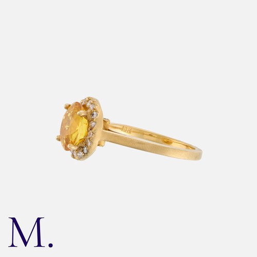 22 - A Yellow Sapphire and Diamond Ring in 14k yellow gold, set with an oval-cut deep yellow-orange colou... 