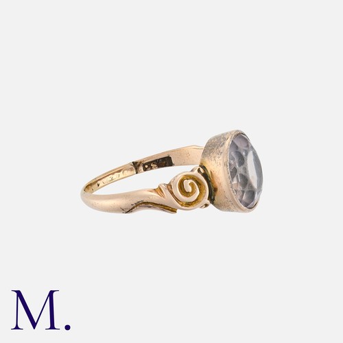 26 - An Amethyst Ring in yellow gold, set with an oval cut amethyst with scrolling accents to the shoulde... 