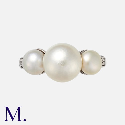 102 - A Natural Pearl Three Stone Ring in platinum set with three pearls to an engraved band. With a gemol... 