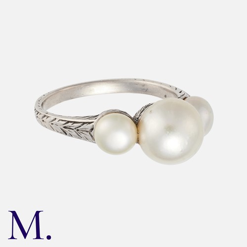 102 - A Natural Pearl Three Stone Ring in platinum set with three pearls to an engraved band. With a gemol... 