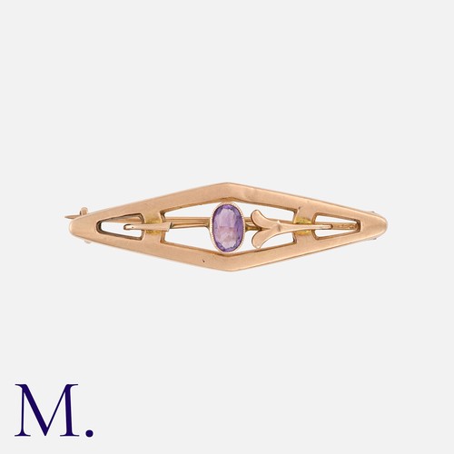 266 - An Amethyst Brooch in 9K rose gold in rhomboidal form with an oval cut amethyst to the centre. Stamp... 