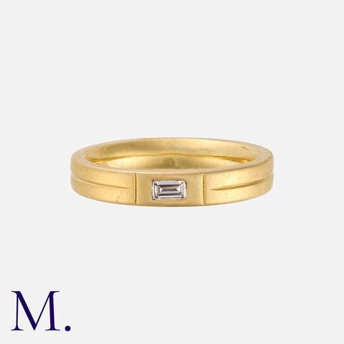 178 - A Diamond Accent Band in 18K yellow gold set with a single baguette cut diamond accent weighing appr... 